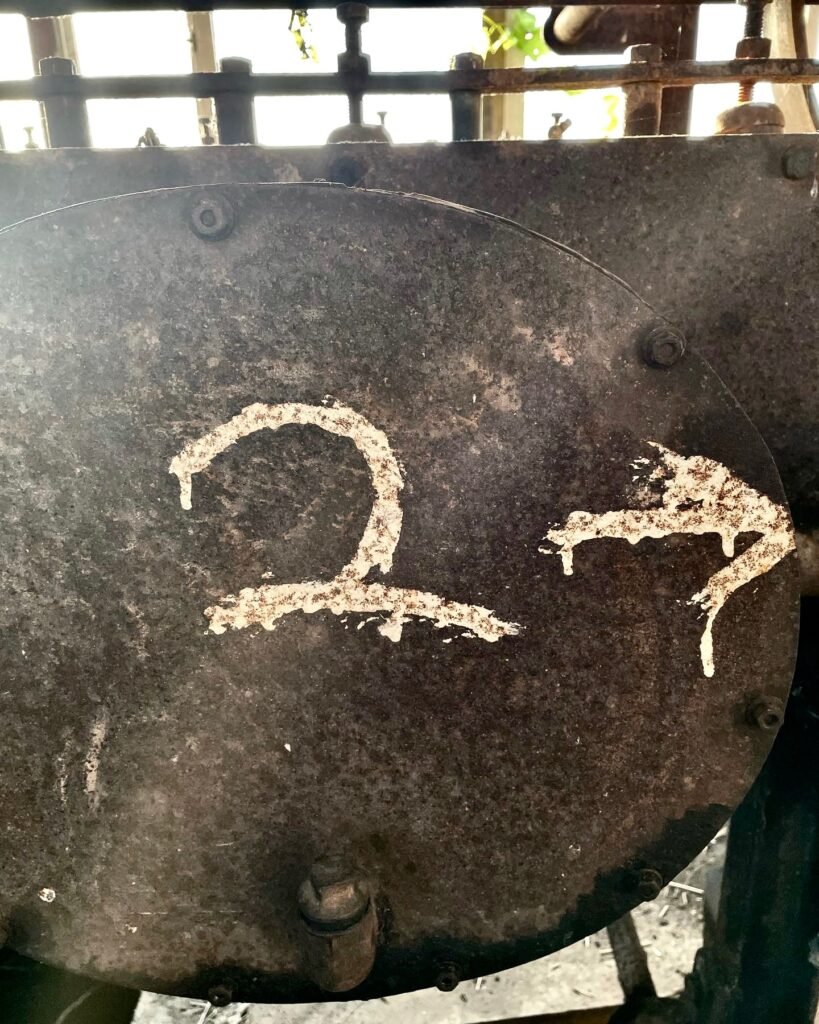 Part of a restored flax scutcher machine with a number painted on it