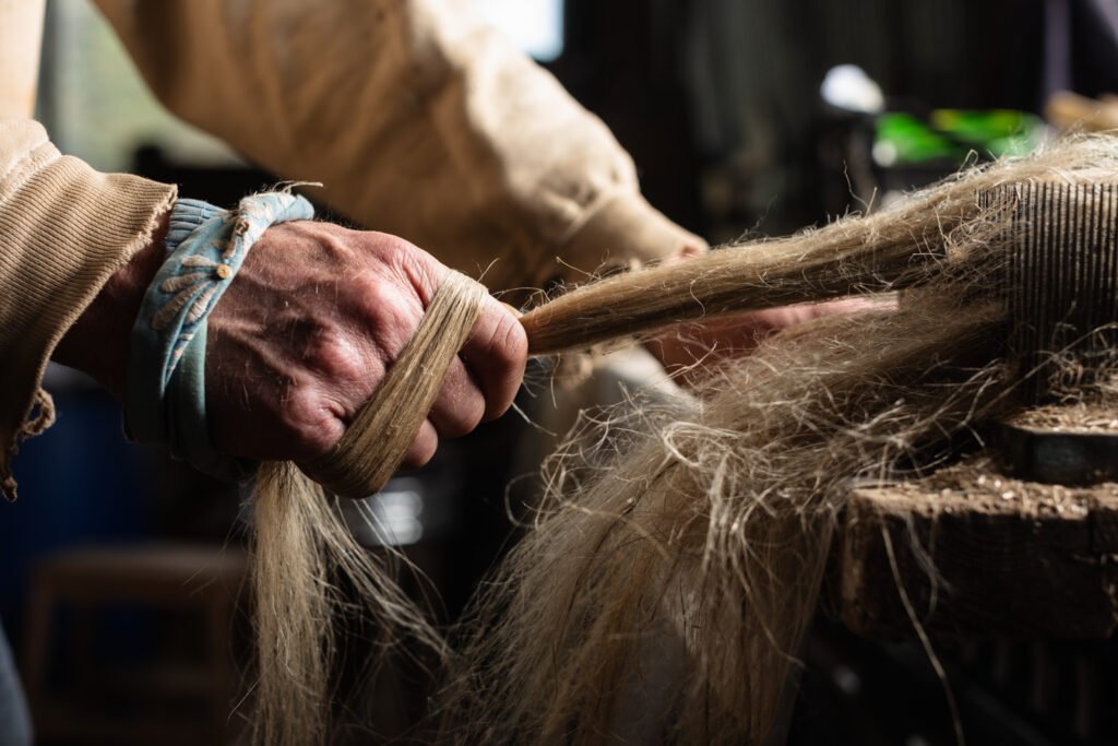 Hackling flax by hand. Photo credit: Yvette Monahan